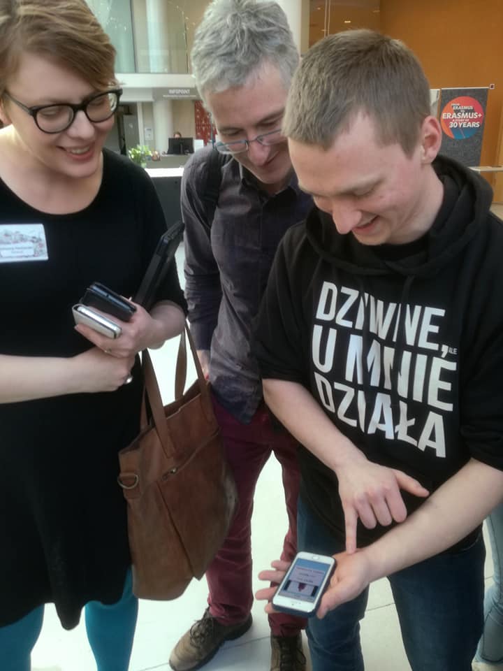 Three people looking at a mobile phone application