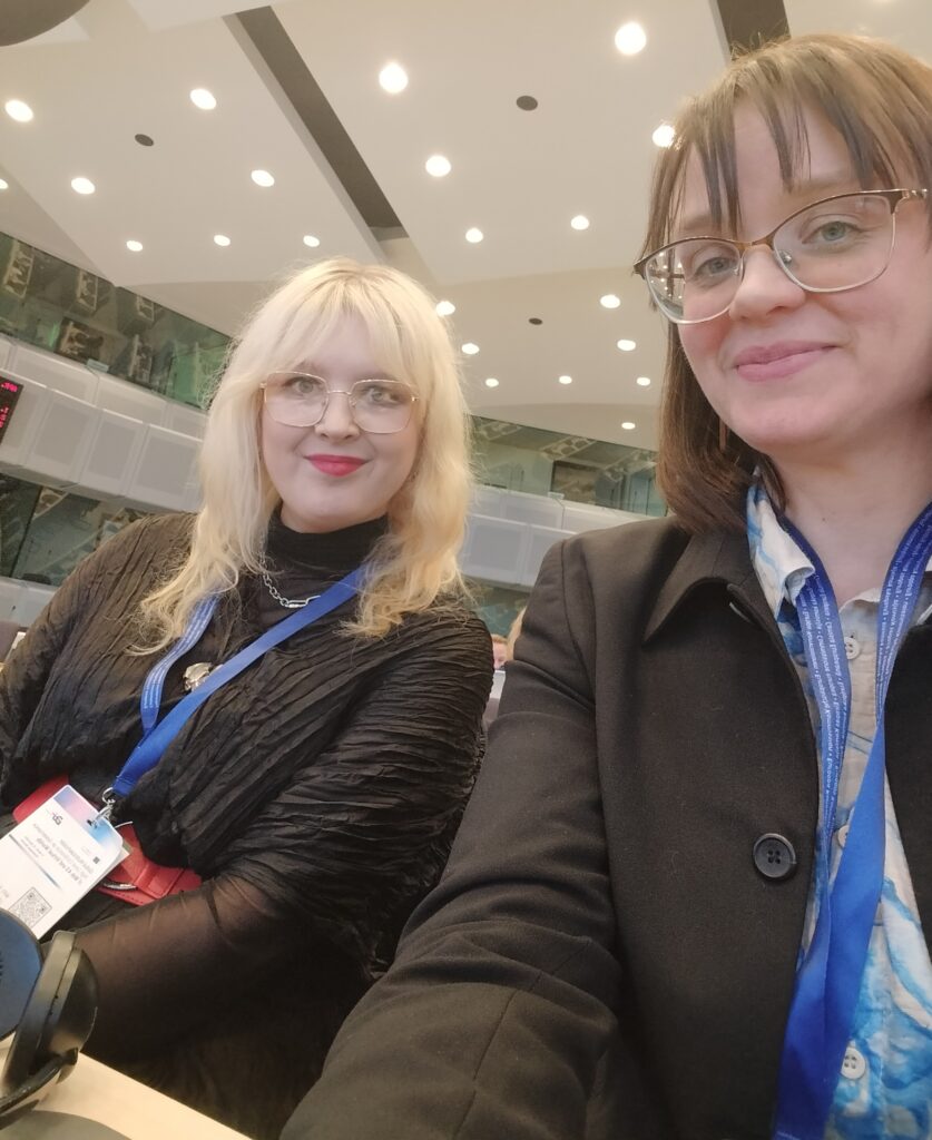 Brysselissä Sharlemangessa suuressa konferenssisalissa otettu selfie, jossa hymyilevät Leena Toivanen ja Laura Palovuori.
