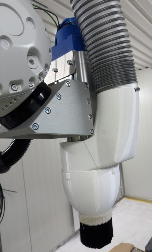 Robottiin asennettua leikkauskaraa ympäröi 3D-tulostettu leikkauspölyn kohdepoistoon soveltuva imuhuuva.