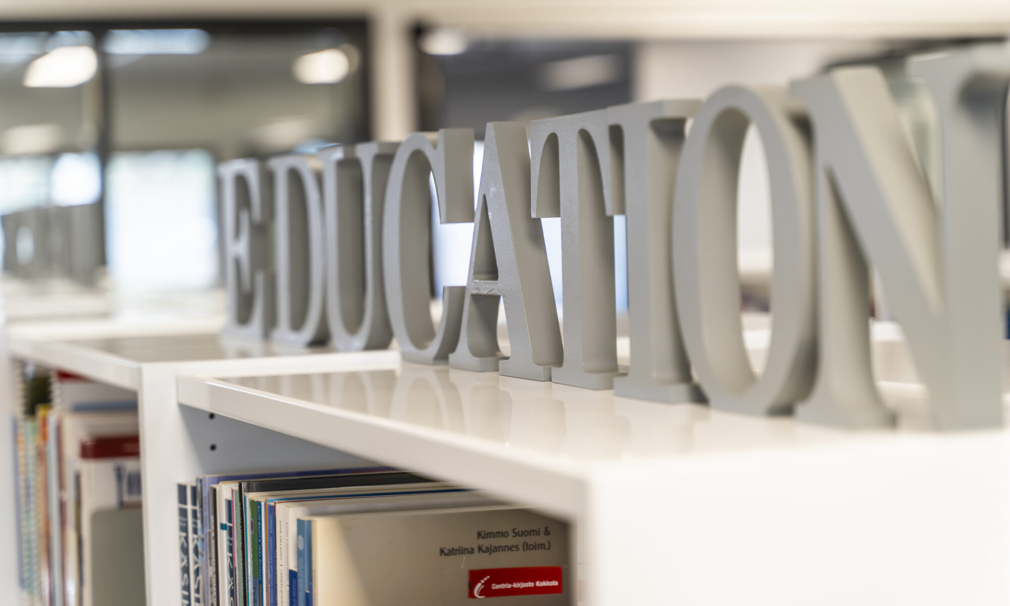 Artikkelikuvassa puisista kirjaimista muodostuva sana education kirjaston hyllyn päälle sijoitettuna.